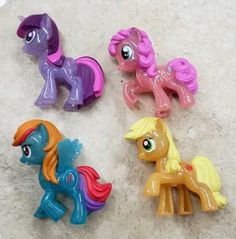 four little pony toys are laying on the floor