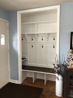 a room that has some white benches and wooden flooring in front of blue walls