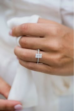 a close up of a person wearing a wedding ring with a cross on the band