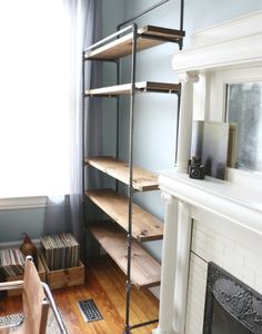 a living room with a fire place and bookshelf next to a window in the corner