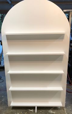 a white book shelf sitting on top of a hard wood floor