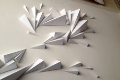 several pieces of paper are arranged in the shape of an origami bird on a white surface