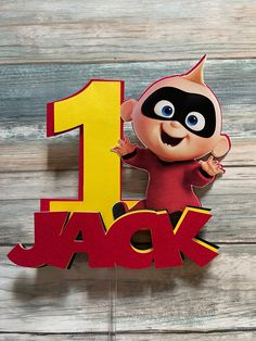 a birthday cake topper with the number one jack in front of an image of a cartoon character