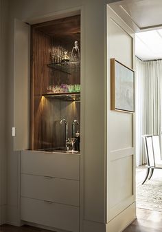 an open cabinet with wine glasses in it