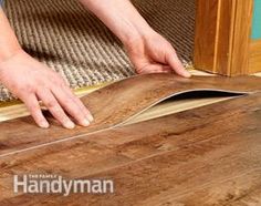 a man is laying wood flooring on the ground with his hands and fingers touching it