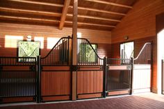 the inside of a horse stable with wooden walls and doors on either side of it