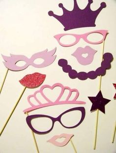 some pink and purple masks are on top of sticks with red glitter stars around them