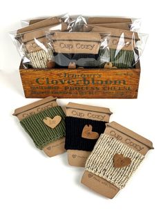 four pairs of coffee cozy mitts in a wooden box with the words cup cozy written on them