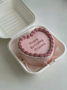 a pink heart shaped cake in a plastic container