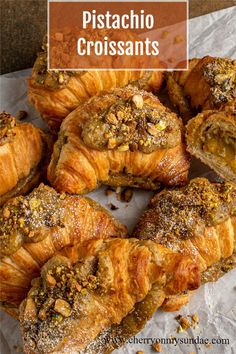 some croissants are sitting on a piece of paper with the words pistachio croissants