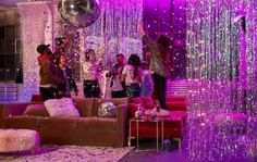 a group of people standing around a living room filled with purple and silver confetti