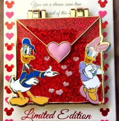 the donald and daisy pin is on display in front of a valentine's day card