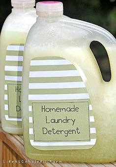 two gallon jugs of homemade laundry deterant sitting on a wooden table