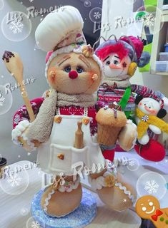 two stuffed animals dressed as chefs and bakers on a table with snowflakes