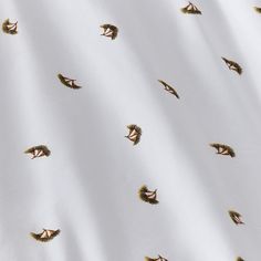 an image of birds flying in the air on a white background with gold foiling