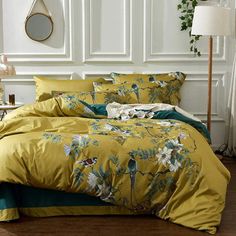 a bed with yellow and green comforters in a room next to a white wall