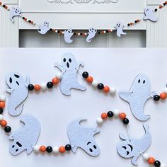 halloween decorations made to look like ghostes and pumpkins are hanging on the wall