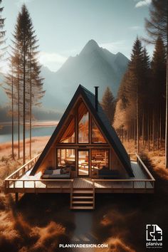 a frame cabin in the woods with stairs leading up to it and mountains in the background