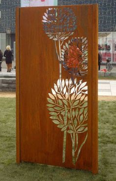 a wooden sculpture with flowers on it in the grass