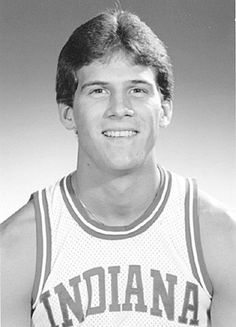 an old black and white photo of a young man in a basketball uniform smiling for the camera