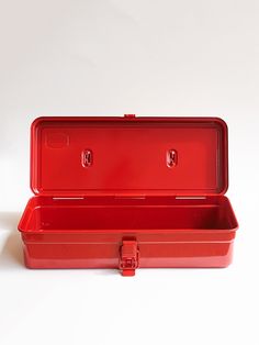 an empty red plastic box on a white surface with the lid open and two latches visible