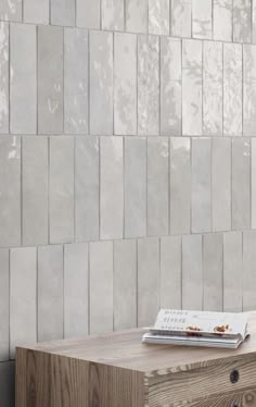 a wooden table sitting in front of a wall with a book on top of it