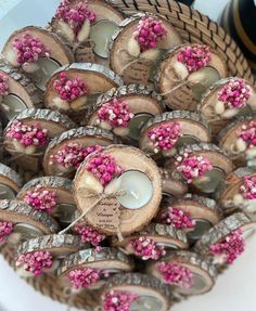 a basket filled with lots of wooden slices covered in pink and white sprinkles