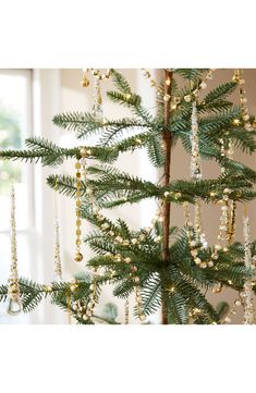 a small christmas tree with beads hanging from it's branches