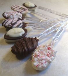 chocolate covered desserts are lined up on a counter top with candy canes and marshmallows