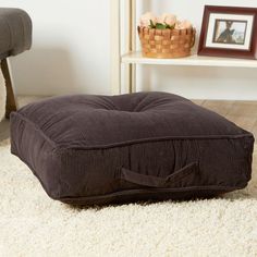 a brown dog bed sitting on top of a white rug