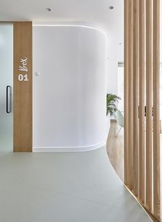 a white room with wooden slats on the wall and a round door in the center