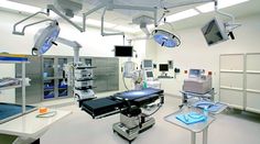 an operating room with multiple monitors and medical equipment on the ceiling, including surgical lights