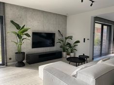 a living room filled with furniture and a flat screen tv mounted on the wall above it