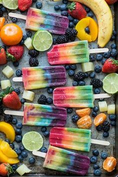 popsicles with fruit, lemons, blueberries and bananas on a baking sheet