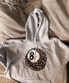 a grey hoodie with the number eight printed on it and a leopard print ball