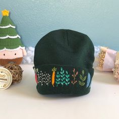 "The embroidered beanie hat is handmade one stitch at a time on hat. It is embroidered only on the front. Measurement: 8\" in length." Casual Beanie With Embroidered Logo, Green Cotton Beanie Cap, Embroidered Logo Cap As Gift, Cotton Winter Hat As A Gift, Cotton Winter Hat As Gift, Cotton Winter Hat For Gift, Winter Cotton Hat For Gifts, Winter Cotton Hat As Gift, Winter Embroidered Cotton Hat