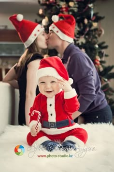 a baby sitting on the floor wearing a santa hat