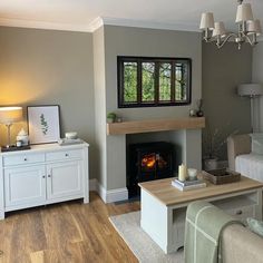 a living room filled with furniture and a fire place next to a couch in front of a fireplace