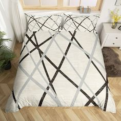 a bed with white and black comforters in a room