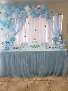 a blue and white dessert table with balloons