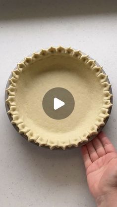 a person is holding a pie pan with the video in front of it to see if they are ready to bake