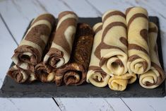 there are four different types of food on the trays and one is rolled up