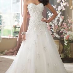 a woman in a white wedding dress posing for the camera