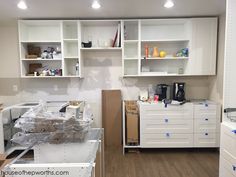 a kitchen with white cabinets and wooden floors