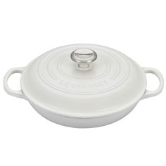 a white casserole dish with an oval handle and handles on the side,