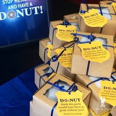 many boxes are tied with blue ribbon and have tags that say donut on them