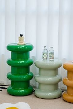 three different colored stools sitting next to each other