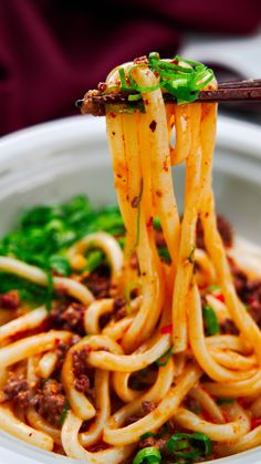 a close up of a bowl of noodles with chopsticks sticking out of it