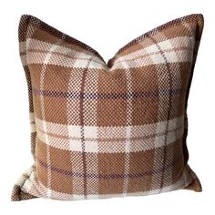 a brown and white plaid pillow on a white background