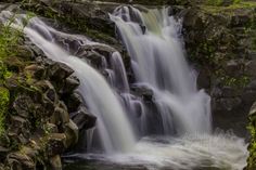 there is a waterfall in the middle of some rocks